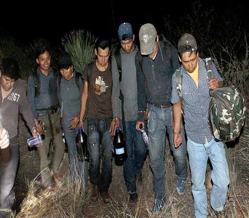 SASABE, AZ - JUNE 01: Undocumented immigrants are escorted from their desert hiding spots after entering the country illegally June 1, 2010 near Sasabe, Arizona. They were captured in a group of 10, working their way through the desert at night about two miles north of the border. During the 2009 fiscal year 540,865 undocumented immigrants were apprehended entering the United States illegally along the Mexican border, 241,000 of those were captured in the 262 mile stretch of the border known as the Tucson Sector. (Photo by Scott Olson/Getty Images)