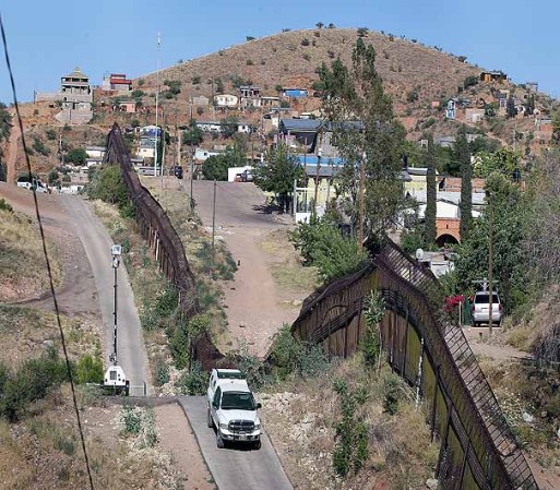 NOGALES, AZ - JUNE 02: A U.S. U.S. Customs and Border Protection agent drives along a fence which separates the cities of Nogales, Arizona and Nogales, Sonora Mexico, a frequent crossing point for people entering the United States illegally, June 2, 2010 in Nogales, Arizona. During the 2009 fiscal year 540,865 undocumented immigrants were apprehended entering the United States illegally along the Mexican border, 241,000 of those were captured in the 262 mile stretch of the border known as the Tucson Sector. (Photo by Scott Olson/Getty Images)