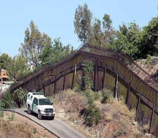 NOGALES, AZ - JUNE 02: A U.S. U.S. Customs and Border Protection agent drives along a fence which separates the cities of Nogales, Arizona and Nogales, Sonora Mexico, a frequent crossing point for people entering the United States illegally, June 2, 2010 in Nogales, Arizona. During the 2009 fiscal year 540,865 undocumented immigrants were apprehended entering the United States illegally along the Mexican border, 241,000 of those were captured in the 262 mile stretch of the border known as the Tucson Sector. (Photo by Scott Olson/Getty Images)