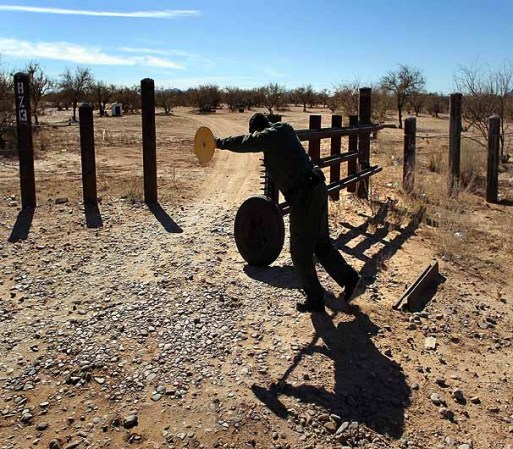 TOHONO O'ODHAM NATION, AZ - JANUARY 18: A U.S. Border Patrol agent closes a gate in the U.S.-Mexico border fence on January 18, 2011 in the Tohono O'odham Nation, Arizona. The Native American reservation, which stradles 72 miles of the border, has several border gates through which Indians are allowed to pass freely between the United States and Mexico. (Photo by John Moore/Getty Images)