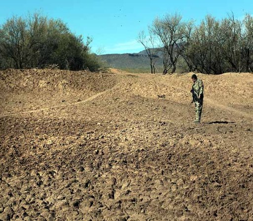 TOHONO O'ODHAM NATION, AZ - JANUARY 19: U.S. Immigration and Customs Enforcement tactical agent John Bothof tracks illegal immigrants' footprints near a pond on January 19, 2011 in the Tohono O'odham Nation, Arizona. He said that immigrants and drug smugglers often stop to drink while crossing the Sonoran Desert from Mexico. Bothof is a member of the Shadow Wolves, the only Native American unit of the U.S. Immigration and Customs Enforcement agency. The ICE unit tracks and interdicts primarily drug smugglers crossing into the Indian reservation along a 72-mile stretch of the U.S.-Mexico border. (Photo by John Moore/Getty Images) *** Local Caption *** John Bothof