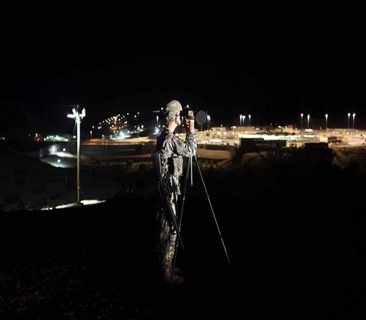NOGALES, AZ - JUNE 22: U.S. Army National Guardsman Spc. Roy Jewell, 21, looks through a thermal imaging camera while seaching for illegal immigrants and drug smugglers crossing the U.S.-Mexico border on June 22, 2011 in Nogales, Arizona. The Pentagon recently extended the deployment of some 1,200 guardsmen who were deployed last year to assist with border security on the U.S.-Mexico border until September 30. Soldiers at Early Identification Team (EIT) observation posts in Nogales work 24 hour shifts, each taking turns resting for 4 hours during the night. The National Guard troops are strictly on surveillance duty, although they are armed and have been credited with helping U.S. Border Patrol agents arrest up to 17,000 illegal immigrants crossing into the United States. (Photo by John Moore/Getty Images)