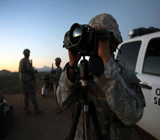 NOGALES, AZ - JUNE 22: U.S. Army National Guardsman Sgt. Oscar Escobar scans the U.S.-Mexico border at dusk on June 22, 2011 in Nogales, Arizona. The Pentagon recently extended the deployment of some 1,200 guardsmen who were deployed last year to assist with border security on the U.S.-Mexico border until September 30. Soldiers at Early Identification Team (EIT) observation posts in Nogales work 24 hour shifts, each taking turns resting for 4 hours during the night. The National Guard troops are strictly on surveillance duty, although they are armed and have been credited with helping U.S. Border Patrol agents arrest up to 17,000 illegal immigrants crossing into the United States. (Photo by John Moore/Getty Images)