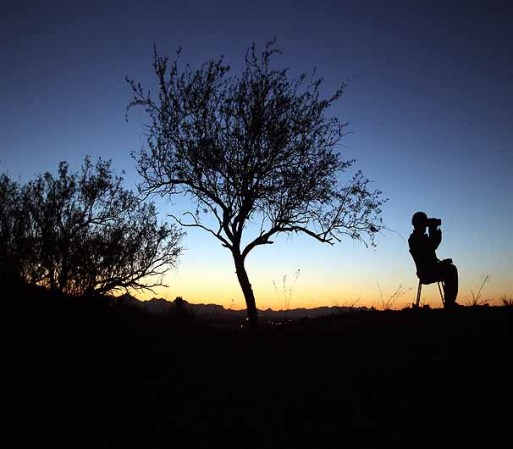 NOGALES, AZ - JUNE 22: U.S. Army National Guardsman Sgt. Oscar Escobar scans the U.S.-Mexico border at dusk on June 22, 2011 in Nogales, Arizona. The Pentagon recently extended the deployment of some 1,200 guardsmen who were deployed last year to U.S.-Mexico border until September 30 on the U.S.-Mexico border until September 30. Soldiers at Early Identification Team (EIT) observation posts in Nogales work 24 hour shifts, each taking turns resting for 4 hours during the night. The National Guard troops are strictly on surveillance duty, although they are armed and have been credited with helping U.S. Border Patrol agents arrest up to 17,000 illegal immigrants crossing into the United States. (Photo by John Moore/Getty Images)