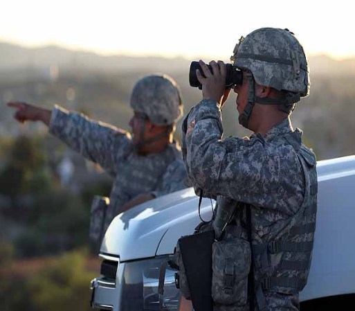 NOGALES, AZ - JUNE 22: U.S. Army National Guardsmen scan the U.S.-Mexico border on June 22, 2011 in Nogales, Arizona. The Pentagon recently extended the deployment of some 1,200 guardsmen who were deployed last year to assist with border security on the U.S.-Mexico border until September 30. Soldiers at Early Identification Team (EIT) observation posts in Nogales work 24 hour shifts, each taking turns resting for 4 hours during the night. The National Guard troops are strictly on surveillance duty, although they are armed and have been credited with helping U.S. Border Patrol agents arrest up to 17,000 illegal immigrants crossing into the United States. (Photo by John Moore/Getty Images)