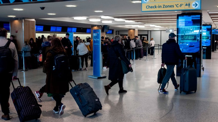 People walk in the departure hall of Terminal 7 at JFK