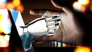 Ilustración de mano con apariencia robótica brota de una pantalla de computadora y toca la mano de una persona frente a ella.