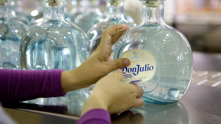 A worker applies a label to a bottle of Don Julio Blanco tequila at Tequila Don Julio SA de CV’s La Primavera distillery in Atotonilco, in the state of Guadalajara, Mexico, on Thursday, Feb. 27, 2014. Tequila Don Julio SA de CV makes a range of handcrafted, 100 percent blue Weber agave tequilas. Mexico is working to export more tequila to China, Foreign Minister Jose Antonio said in an interview on Feb. 27. Photographer: Susana Gonzalez/Bloomberg via Getty Images