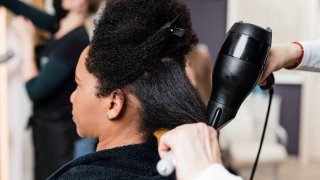 mujer alisándose el pelo