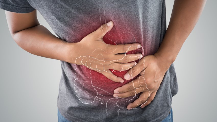 The photo of large intestine is on the man’s body against gray background, People With Stomach ache problem concept, Male anatomy