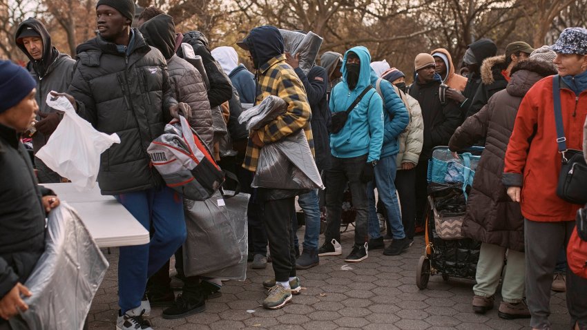 ARCHIVO – Migrantes toman mantas cerca de un Centro de Ayuda a Migrantes en la escuela primaria St. Brigid, el martes 5 de diciembre de 2023, en Nueva York. (AP Foto/Andres Kudacki, Archivo)