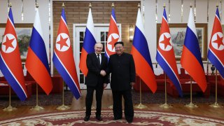 En esta fotografía de grupo distribuida por la agencia estatal rusa Sputnik, el presidente ruso Vladimir Putin (izq.) le da la mano al líder de Corea del Norte, Kim Jong Un, durante una reunión en Pyongyang el 19 de junio de 2024. Putin disfrutó de una bienvenida en la alfombra roja, una ceremonia militar y un abrazo de Kim Jong Un de Corea del Norte durante una visita de estado a Pyongyang, donde ambos prometieron forjar vínculos más estrechos.