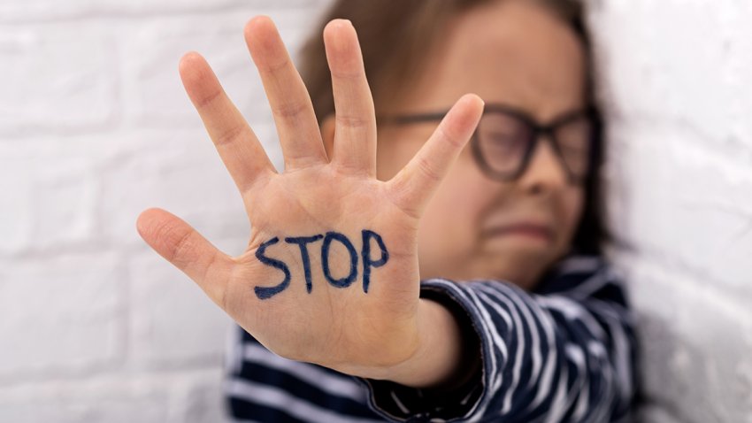 A little girl shows her hand with the inscription STOP. Domestic Violence. Child abuse.