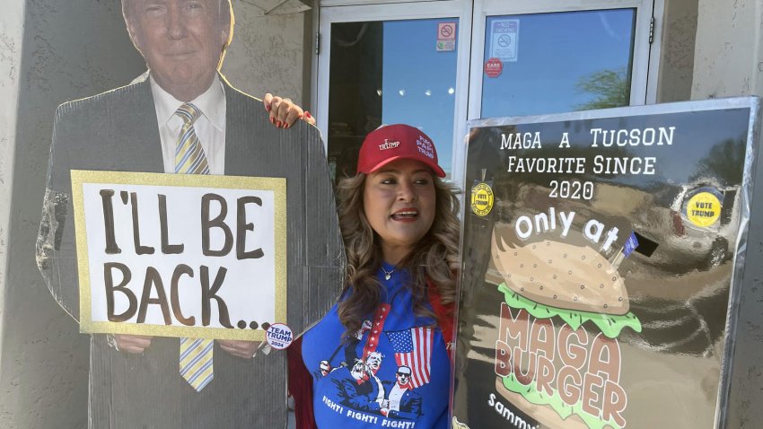 FotografÌa del 28 de septiembre de 2024 de la mexicana Betty Rivas, posando junto a los carteles a favor del expresidente republicano Donald Trump, uno con su imagen que dice ‘I’ll be back’ (VolverÈ) y otro de su hamburguesa ‘MAGA Burguer’, bautizada con las siglas de la campaÒa de Trump ‘Make America Great Again’ (Hacer EEUU grande de nuevo), en la puerta de su restaurante Sammy’s Mexican Grill, en Catalina, Arizona (Estados Unidos). EFE/ Ana Milena VarÛn