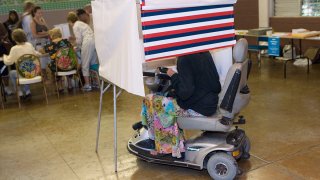 Una mujer en una silla de ruedas motorizada deposita su voto en Honolulu, el 4 de noviembre del 2008.