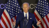 Biden stands in front of flags