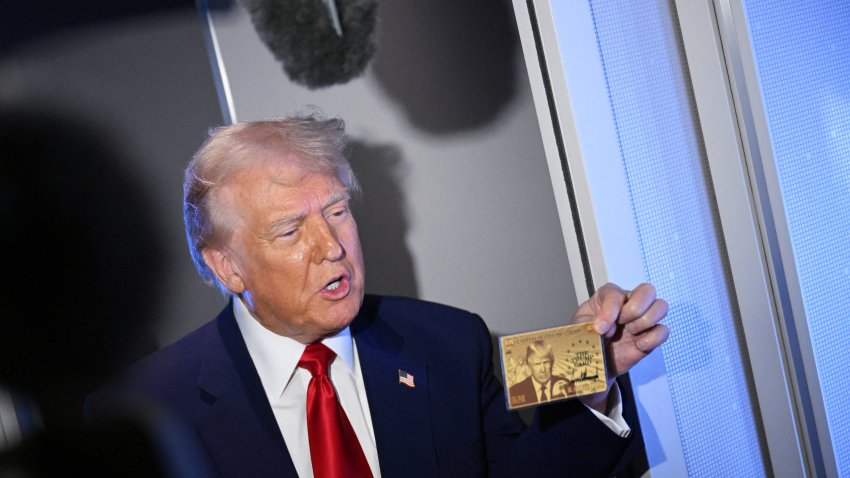 US President Donald Trump holds the $5 million dollar Gold Card as he speaks to reporters while in flight on board Air Force One, en route to Miami, Florida on April 3, 2025. Trump is travelling to the Trump National Doral Golf Club before going to his Mar-a-Lago Resort. (Photo by MANDEL NGAN / AFP) (Photo by MANDEL NGAN/AFP via Getty Images)