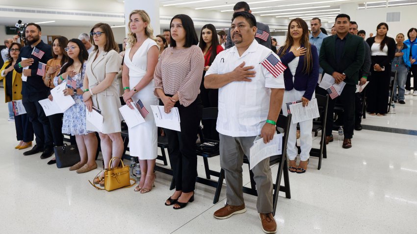 New US citizens stand for the national anthem before taking the Oath of Allegiance and receiving their naturalization certificates during a formal ceremony at Midway International Airport in Chicago, Illinois, on June 25, 2025. The new citizens, approximately 25 Chicago-area residents, hail from six countries: Jordan, Mexico, Poland, Russia, Spain, and Yemen. (Photo by KAMIL KRZACZYNSKI / AFP) (Photo by KAMIL KRZACZYNSKI/AFP via Getty Images)