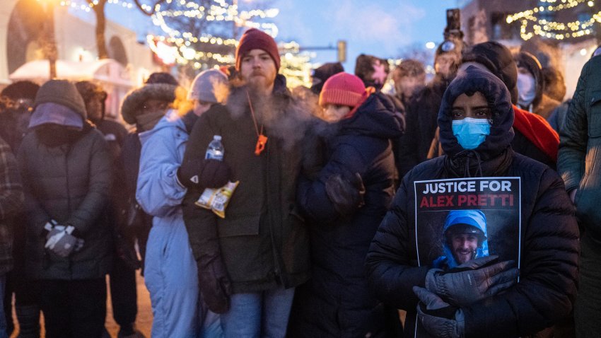 People mourn at a makeshift memorial in the area where 37-year-old Alex Pretti was shot dead by federal immigration agents earlier in the day in Minneapolis, Minnesota, on January 24, 2026. Federal immigration agents shot dead a man in Minneapolis on Saturday, in the second fatal shooting of a civilian during the Trump administration’s unprecedented operation in the city, sparking fresh protests and outrage from state officials. The death came less than three weeks after US citizen Renee Good was shot and killed by an ICE officer. (Photo by ROBERTO SCHMIDT / AFP via Getty Images)