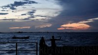 ARCHIVO – Gente sentada en un muelle al atardecer en Georgetown, Guyana, el martes 19 de noviembre de 2024. (AP Foto/Matias Delacroix, Archivo)