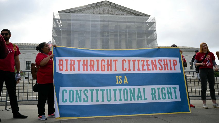 People hold a sign as they participate in a protest outside the US Supreme Court over President Donald Trump’s move to end birthright citizenship as the court hears arguments over the order in Washington, DC, on May 15, 2025. Trump issued an executive order on his first day in office seeking to limit birthright citizenship for children whose parents are in the United States illegally or on temporary visas, but it has been blocked in multiple appellate courts. He appealed the case to the Supreme Court on March 13. (Photo by Drew ANGERER / AFP) (Photo by DREW ANGERER/AFP via Getty Images)